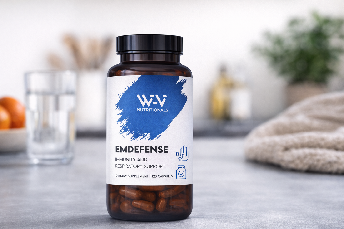 Supplement bottle labeled 'EmDefense' by W-Vi Nutritionals on a blurred kitchen background